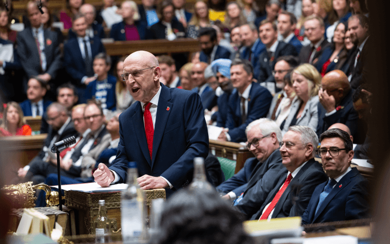 John Healey delivering the budget in front of a crowd of Labour MPs in the Commons, including Andy Burnham
