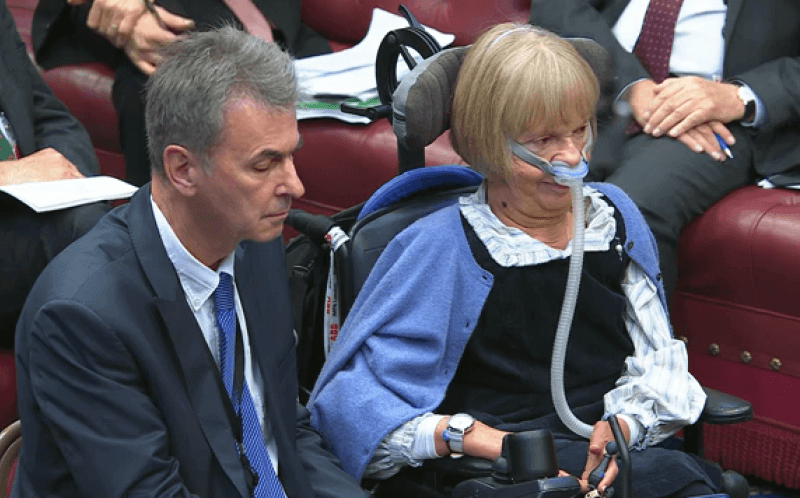 Baroness Campbell in the House of Lords in her wheelchair and wearing a ventilator