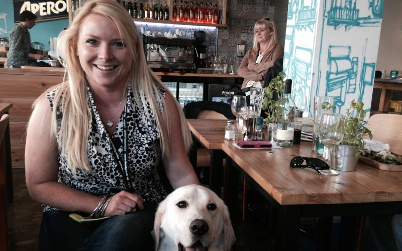Jenny Nedwell sitting in restaurant with guide dog