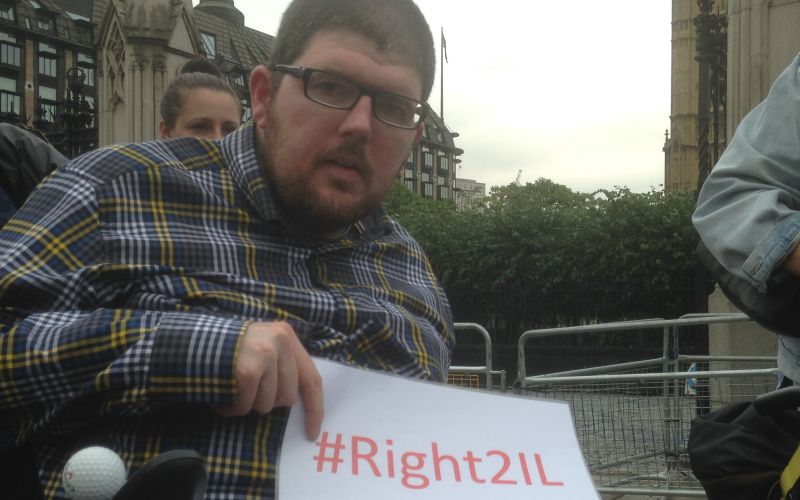 Nathan Lee Davies holding a sign saying #Right2IL
