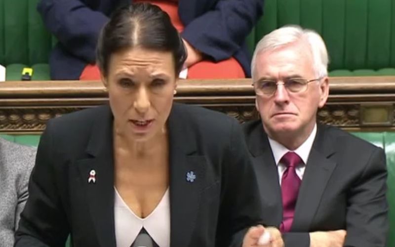 Debbie Abrahams speaking in parliament, with John McDonnell sitting behind her