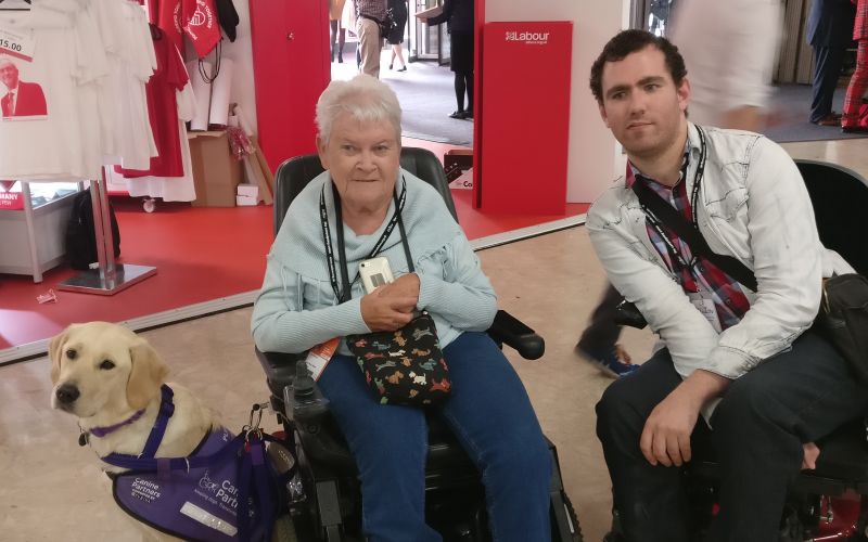 Anne Pridmore, her assistance dog, and Alex Hovden at the conference
