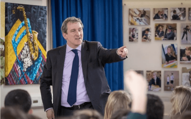 Damian Hinds pointing with his finger in a room of children