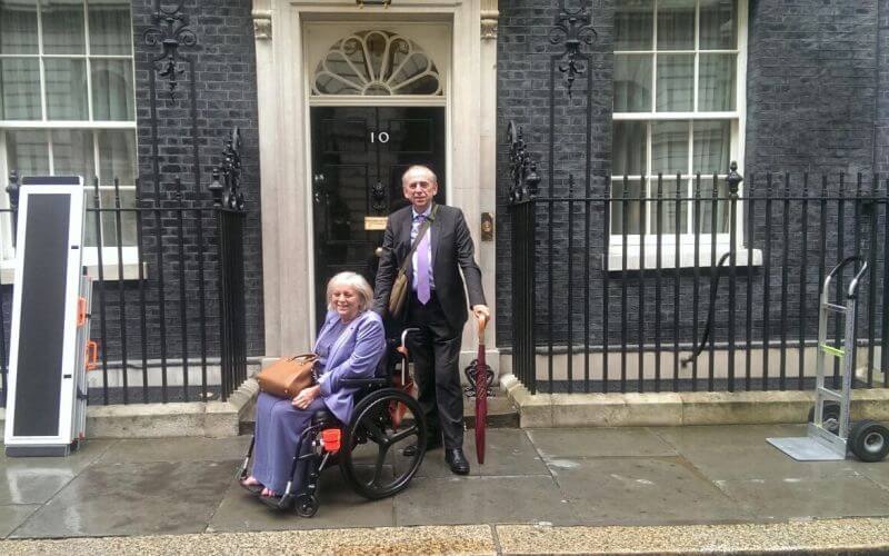 A female wheelchair-user and a man outside No 10