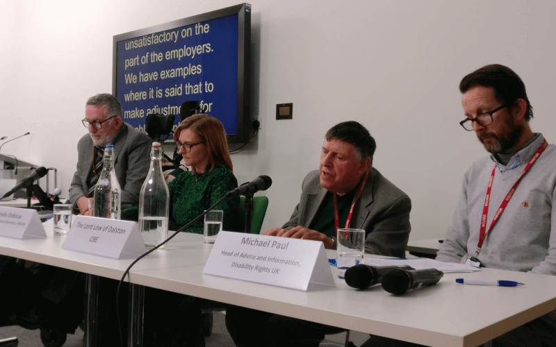 Four people behind a table with microphones
