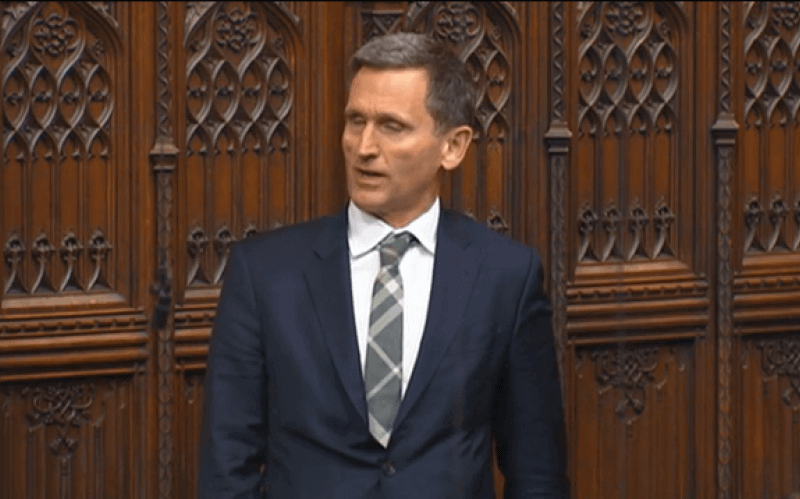 Lord Holmes speaking in the House of Lords, with carved wooden panelling behind him