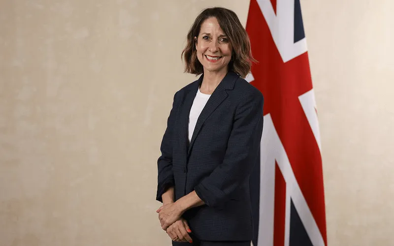 Liz Kendall standing in front of a union flag, smiling
