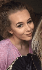 Philippa Day smiling and standing behind a friend
