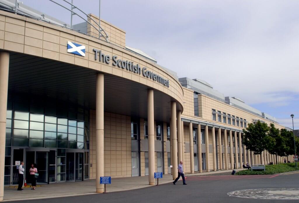 Long yellow brick building with pillars. The Scottish Government is written above the entrance.