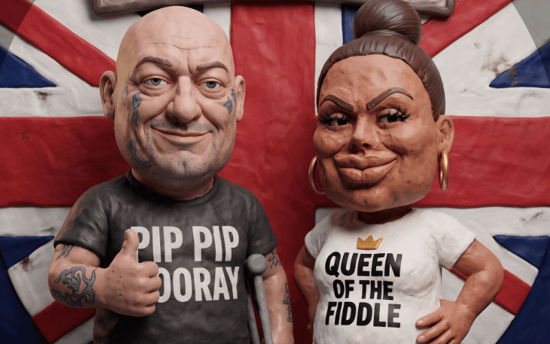 Two animated figures, one a bald man with tattoos on his face, holding a crutch and wearing a tee shirt that says PIP PIP HOORAY, and a woman with her hair tied back and wearing a tee shirt that says QUEEN OF THE FIDDLE